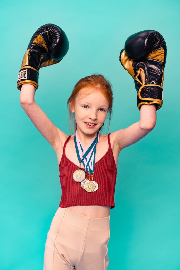 portrait of girl with medals wearing boxing gloves